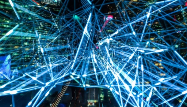 A night cityscape overlaid with glowing blue digital lines and nodes