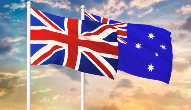 United Kingdom and Australian flags flying side by side against a sunset sky