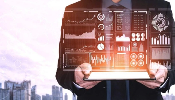 Business professional holding a tablet with digital analytics dashboards and data visualizations projected above the screen