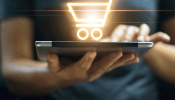 Person using a tablet with a glowing digital shopping cart icon hovering above