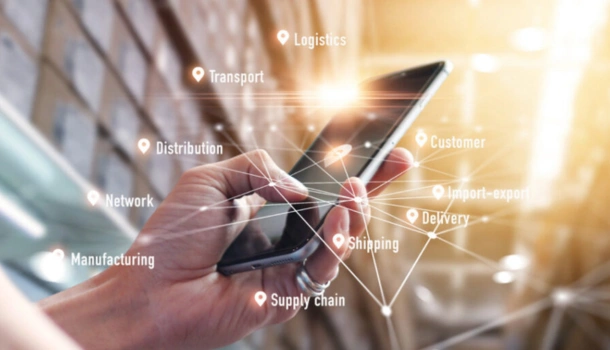 A hand holds a smartphone with digital icons and keywords like "Logistics," "Supply chain," and "Delivery" overlayed