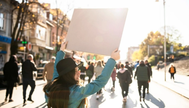 A woman holds up a protest sign