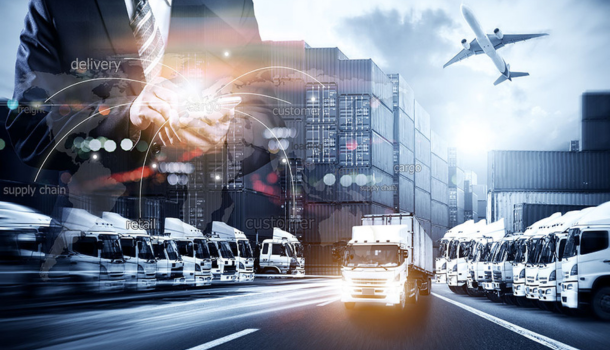 image showing a businessman using a tablet overlaid on a busy logistics hub with trucks, shipping containers