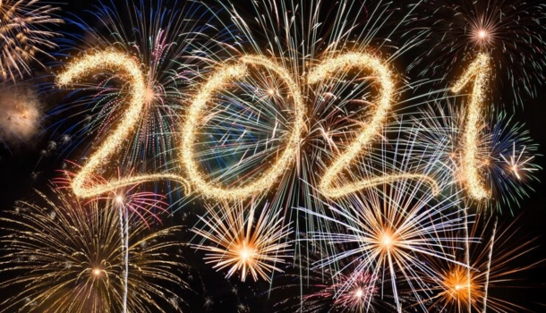 Bright fireworks lighting up the night sky with the number "2021" drawn in sparkling light