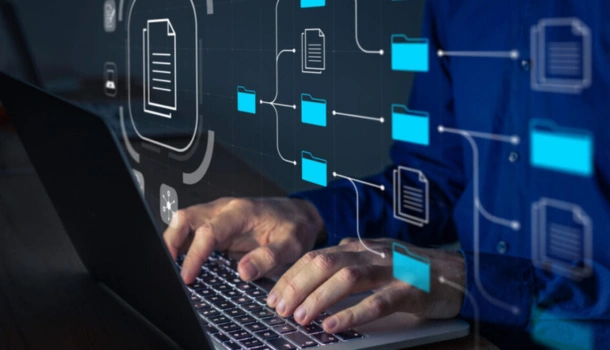 A person types on a laptop with digital icons of folders and documents overlayed
