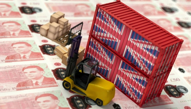 Miniature forklift and stacked cargo containers with Union Jack designs are placed on a background of £50 banknotes